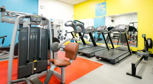 a gym with rows of treadmills and machines at Cedar Court Bradford Hotel in Bradford