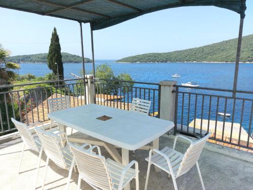 una mesa y sillas en un balcón con vistas al agua en Villa Riva, en Molunat