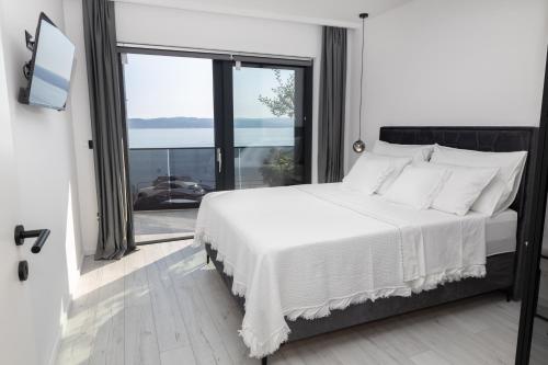 a bedroom with a white bed with a large window at Apartment 1911 in Brela