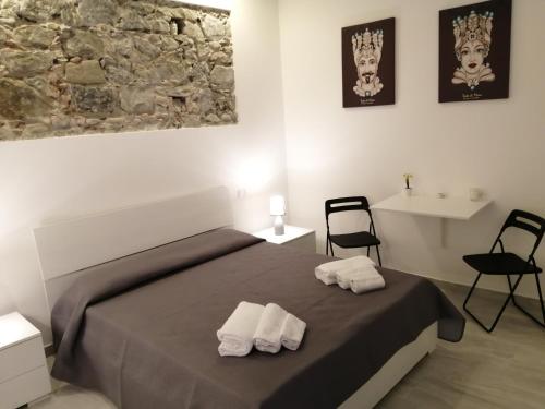 ein Schlafzimmer mit einem Bett mit zwei Handtüchern darauf in der Unterkunft Marvin's Home in Giardini-Naxos