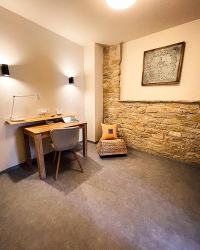 an office with a desk and a stone wall at Hotel-Bistro-Europa in Merchweiler