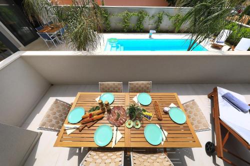 a table on a patio next to a swimming pool at Luxury Aparthotel Zadar in Zadar