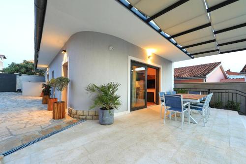 a house with a patio with a table and chairs at Luxury Aparthotel Zadar in Zadar