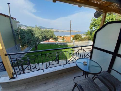 a balcony with a table and chairs and a view of the water at Ilios house in Kavala