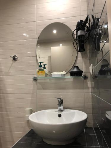 a bathroom with a white sink and a mirror at VASILEVI STUDIOS in Nea Kalikratia