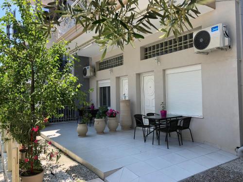 a patio with a table and chairs and plants at VASILEVI STUDIOS in Nea Kalikratia