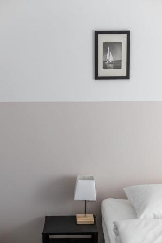a white bedroom with a bed and a table with a lamp at W Sercu Mazur in Harsz
