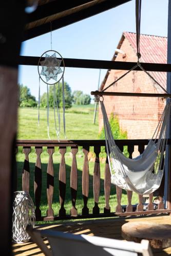 a hammock on a porch with a view of a yard at W Sercu Mazur in Harsz