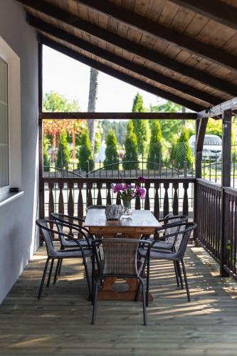 a wooden table and chairs on a balcony with a table and flowers at W Sercu Mazur in Harsz