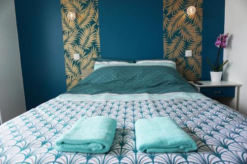 1 dormitorio con 1 cama con 2 almohadas en Appart Chic & Moderne avec balcon en La Roche-sur-Yon