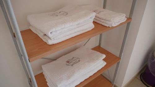 three towels are on a shelf in a room at Masseria Lama D'impisa in Fasano