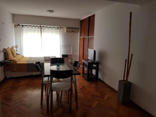 a room with a bed and a table and chairs at Temporarios Peatonal in Rosario