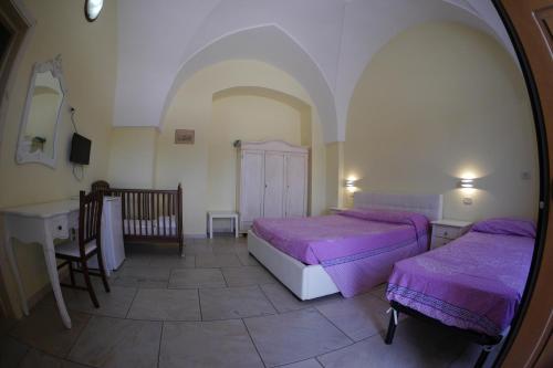 a bedroom with two beds and a table and a mirror at Masseria Lama D'impisa in Fasano