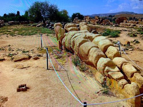a group of rocks lined up next to a fence at La casa di Gioggiò in Ioppolo Giancaxio