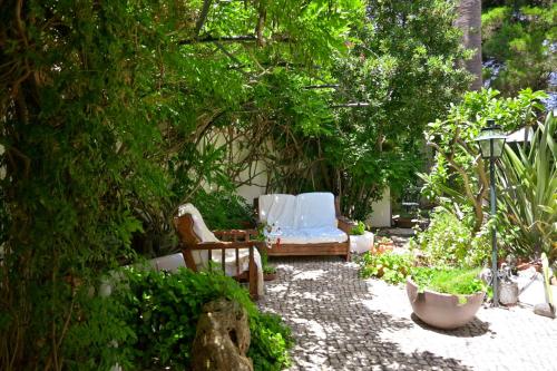 a garden with a couple of chairs and trees at Uma Casa a Beira Sol in Lagos