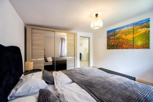 a bedroom with a bed and a painting on the wall at Apartamenty w Górach Sowich in Pieszyce