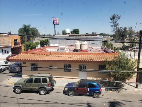 two cars parked in a parking lot in front of a building at Casa Zona Iteso, Expo Guadalajara, Plaza del Sol, Bugambilias. in Guadalajara