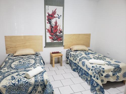 two beds sitting next to each other in a room at Casa Zona Iteso, Expo Guadalajara, Plaza del Sol, Bugambilias. in Guadalajara