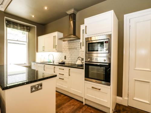 a kitchen with white cabinets and a stove top oven at Bearnock Lodge in Inverness