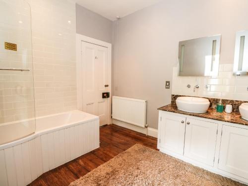 a white bathroom with a tub and a sink at Bearnock Lodge in Inverness