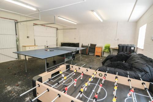 a room with a ping pong table and a couch at Bearnock Lodge in Inverness