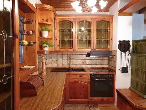a kitchen with wooden cabinets and a stove at Alm-Ferienhaus Gaisegg am Klippitztörl in Bad Sankt Leonhard im Lavanttal