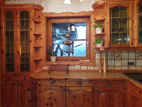 a kitchen with wooden cabinets and a window at Alm-Ferienhaus Gaisegg am Klippitztörl in Bad Sankt Leonhard im Lavanttal