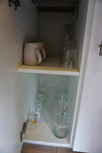 a cupboard filled with glasses and other glass items at Appart Cosy 4 personnes avec terrasse in La Roche-sur-Yon