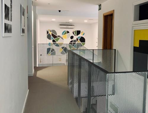 a staircase with a glass railing in a room at LUZ Vejer Hospedería in Vejer de la Frontera