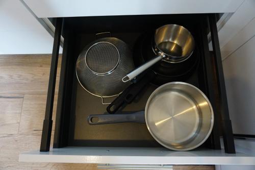 a drawer filled with pots and pans on a shelf at Appart Cosy 4 personnes avec terrasse in La Roche-sur-Yon