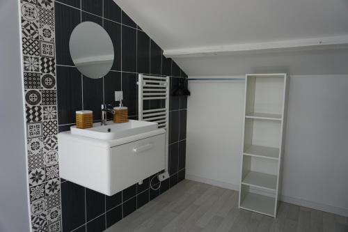 bagno con lavandino bianco e specchio di Appart Cosy 4 personnes avec terrasse a La Roche-sur-Yon