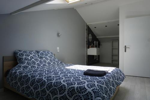 a bedroom with a bed with a blue and white comforter at Appart Cosy 4 personnes avec terrasse in La Roche-sur-Yon