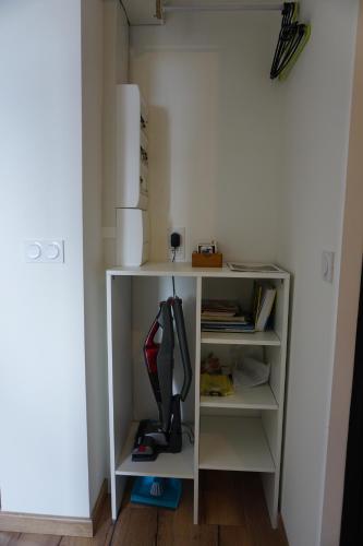 a room with a white book shelf with a hair dryer at Appart Cosy 4 personnes avec terrasse in La Roche-sur-Yon
