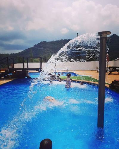 a person in a fountain in a swimming pool at espai Abadia La Trilla in Argentera