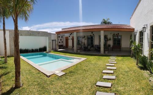 un patio trasero con piscina y una casa en HOTEL PLAZA MATAMOROS en Matamoros