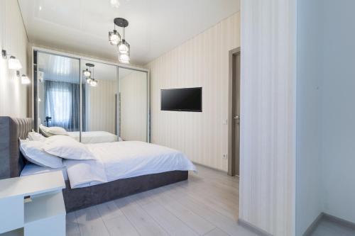 a bedroom with a bed and a tv on the wall at Lux near Most City, river view, center new tower in Dnipro