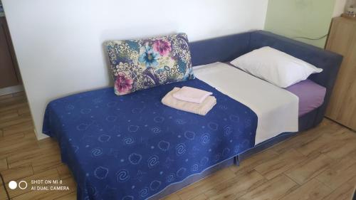 a small bed with a pillow and a towel at Gloria Apartments in Herceg-Novi
