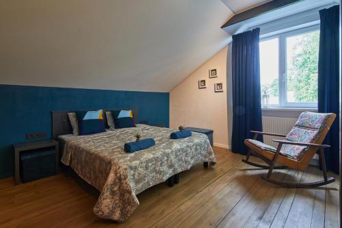 a bedroom with a large bed and a chair at "Parko vila" Anykščiai in Anykščiai