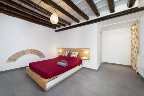 ein Schlafzimmer mit einem roten Bett in einem weißen Zimmer in der Unterkunft MojoCoHouse in Palermo