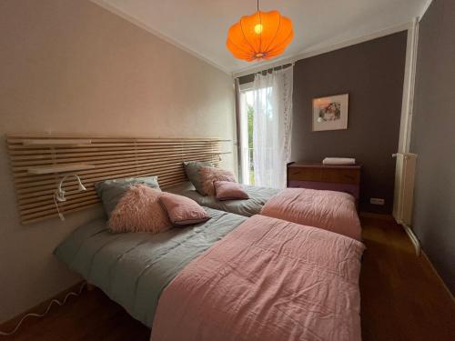 - 2 lits dans une chambre avec une lampe orange dans l'établissement canaille candelle, à Cassis