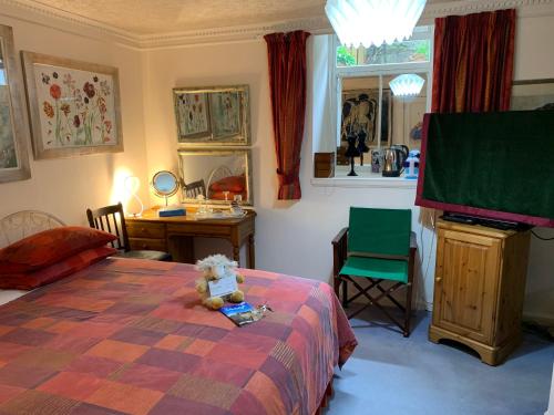 a bedroom with a teddy bear sitting on a bed at geraldsplace in Edinburgh