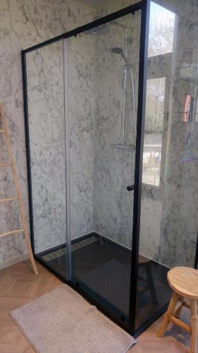 a glass shower with a glass door in a room at B6 in Ursel