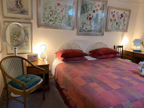 une chambre avec un lit, un miroir et une chaise dans l'établissement geraldsplace, à Édimbourg