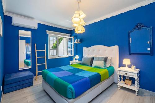 een blauwe slaapkamer met een bed en een raam bij Charming Blue Albufeira in Albufeira
