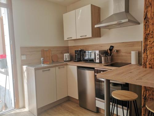 a small kitchen with white cabinets and a counter top at studi'home in Rouen