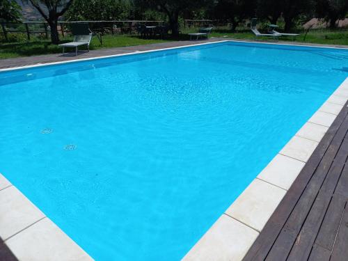 a large blue swimming pool with a wooden deck at Agriturismo Il Rifugio in Battipaglia