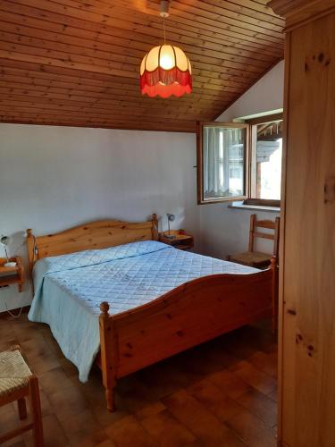 - une chambre avec un lit en bois et un plafond en bois dans l'établissement Appartamenti Dolomiti, à Colcerver