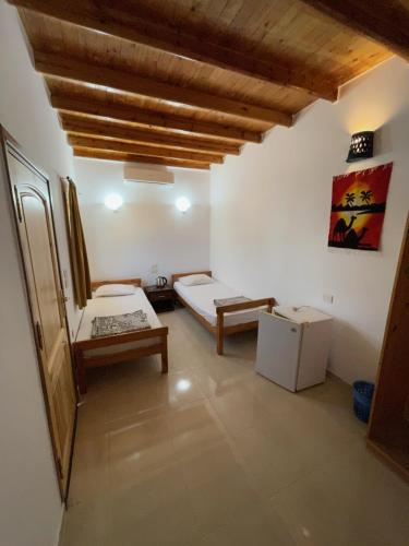 a room with two beds and a table in it at Dolphin Camp in Dahab