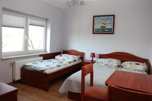 ブワディスワボボにあるPokoje gościnne Rafałのベッド2台とテーブルが備わる客室です。
