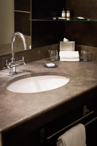 a bathroom counter with a sink and a mirror at La Citadelle Hotel Metz - MGallery Collection in Metz